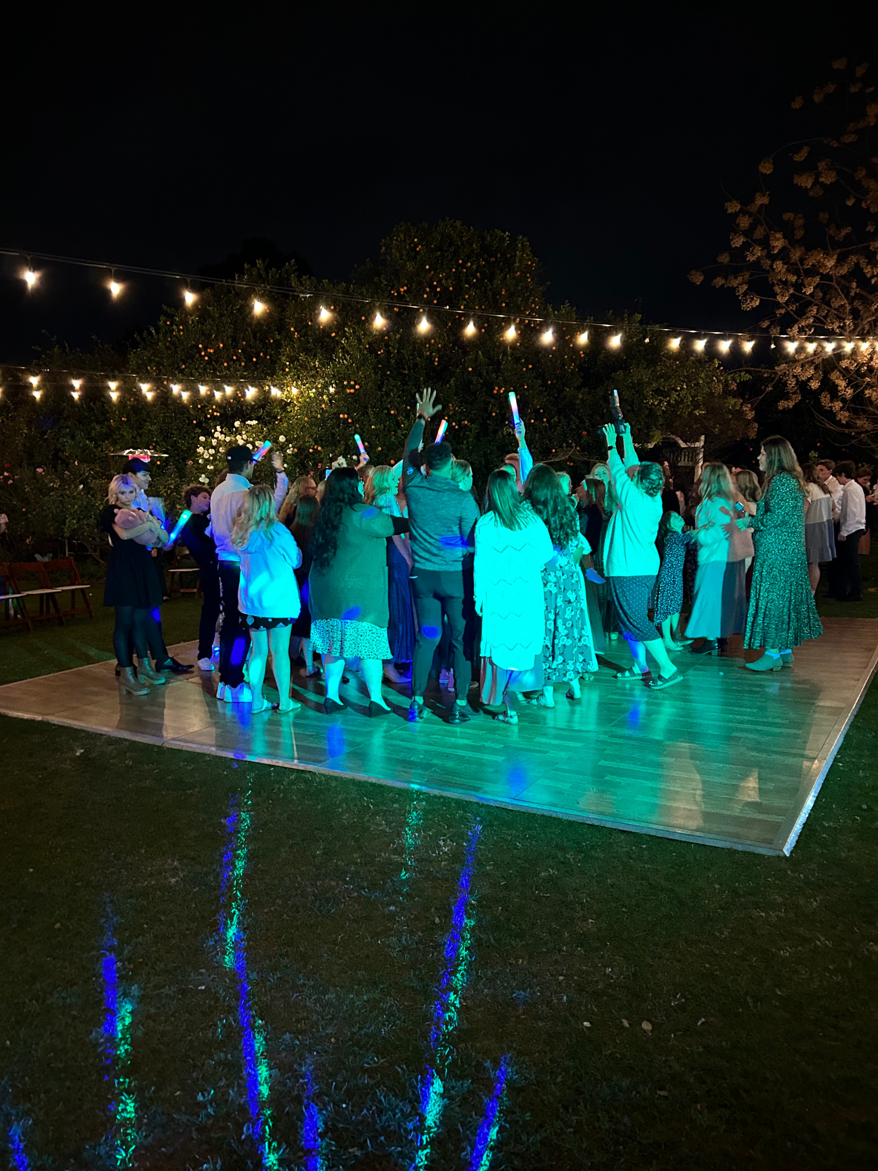 Outdoor party with crowd dancing under lights